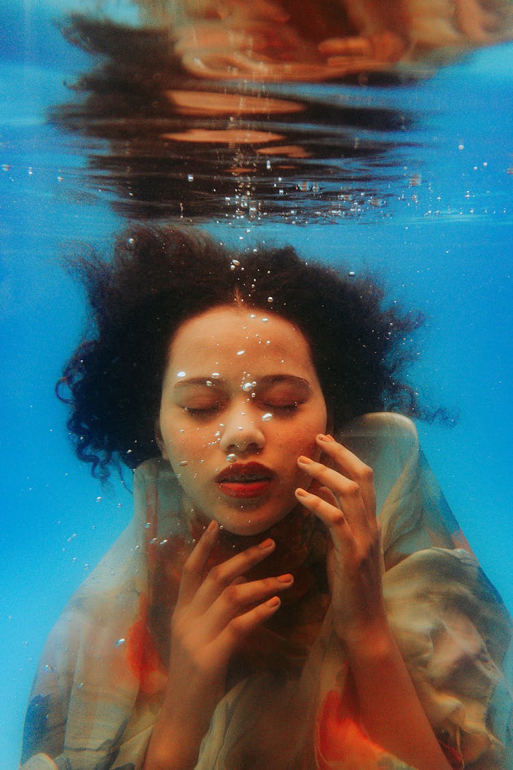 Woman Posing Underwater With Hands Touching Her Face 