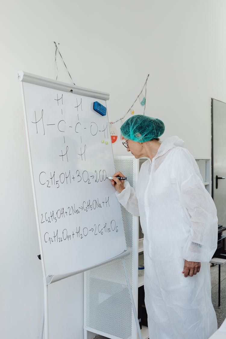 A Woman Scientist Writing On White Board