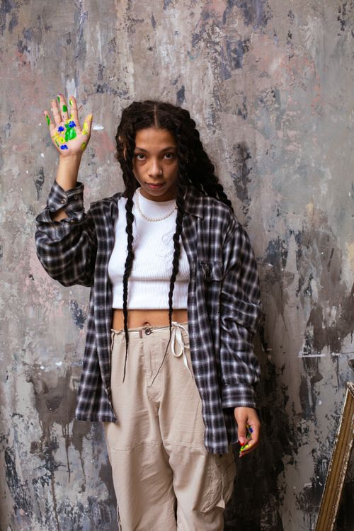 Free Artistic portrait of a woman with paint on her hand, expressing creativity. Stock Photo
