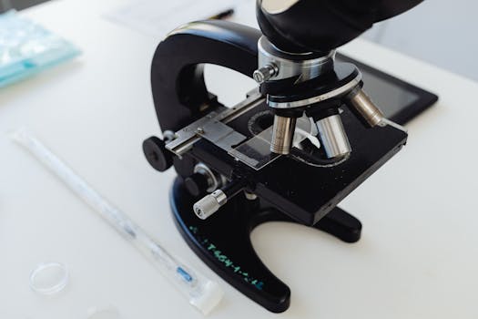 Detailed photo of a microscope on a laboratory desk, symbolizing scientific research.