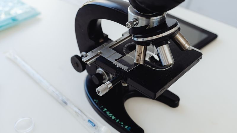 Detailed photo of a microscope on a laboratory desk, symbolizing scientific research.