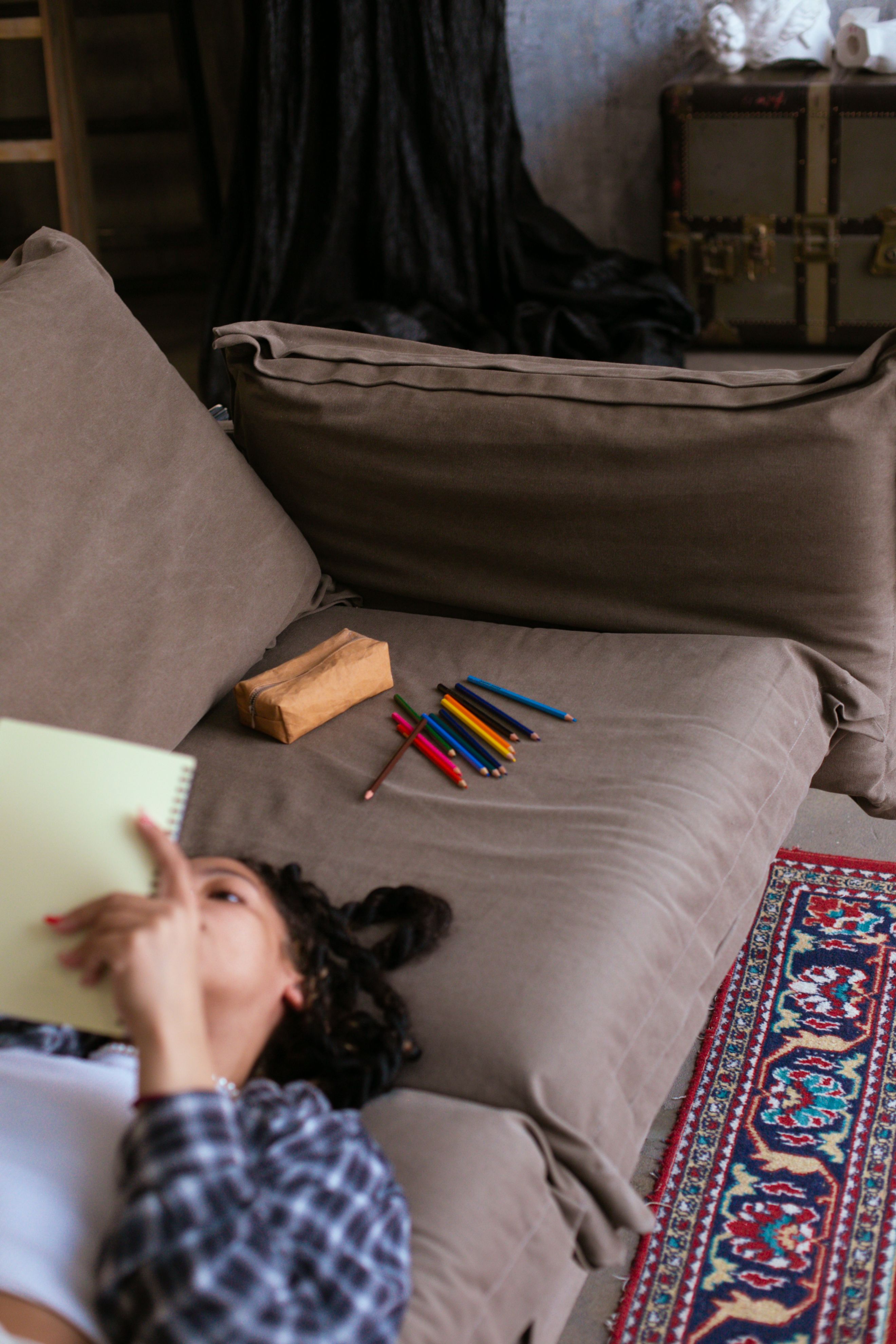 A Woman in Plaid Long Sleeves Reading a Book while Lying on the Sofa ...