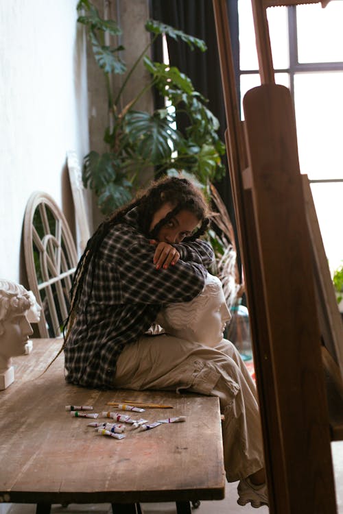 Woman Sitting on Table in Art Studio