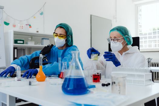Two female scientists examining samples in a bright, modern laboratory setting.