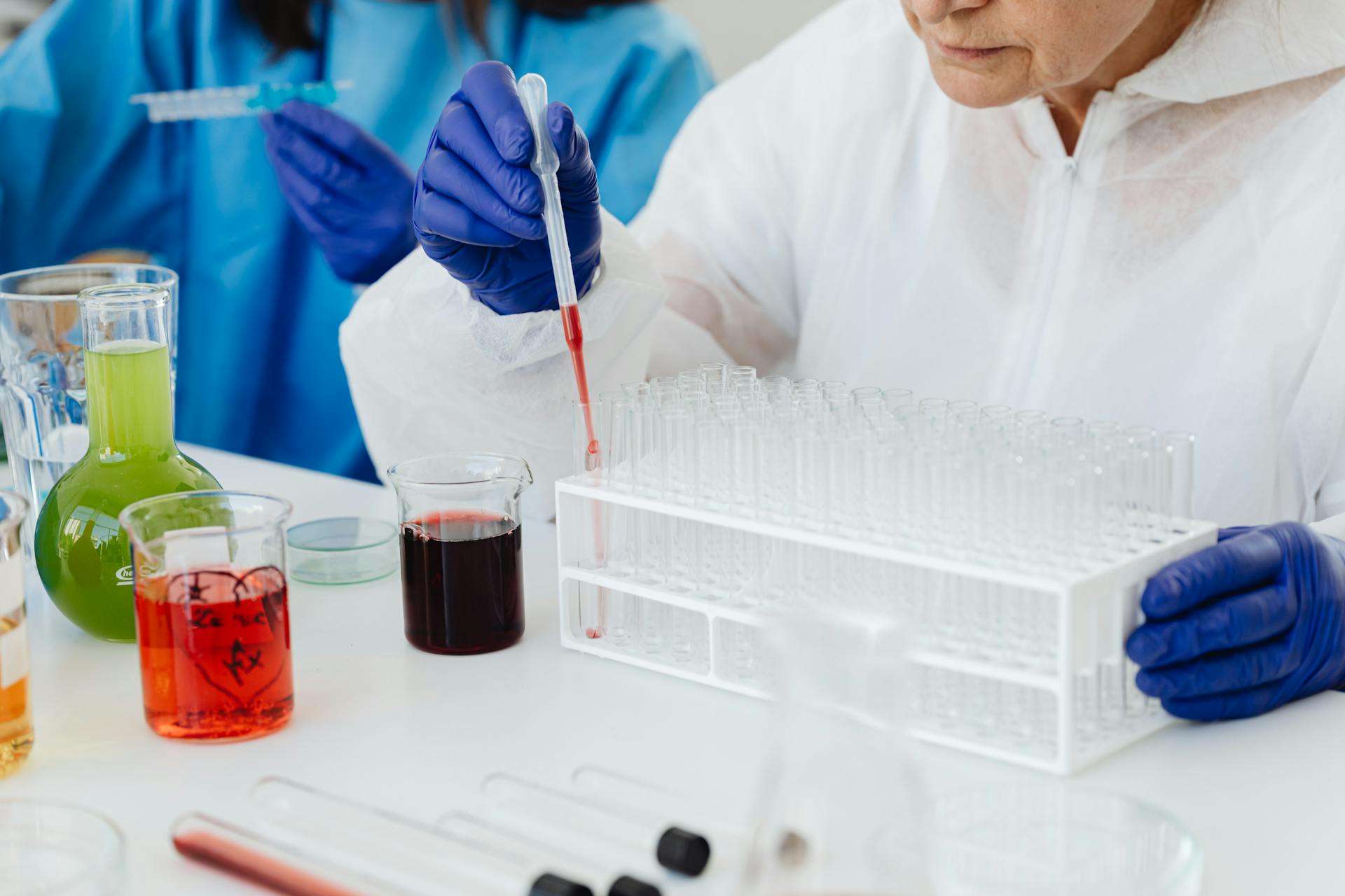 Scientist in Laboratory Filling a Test Tube with a Dropper