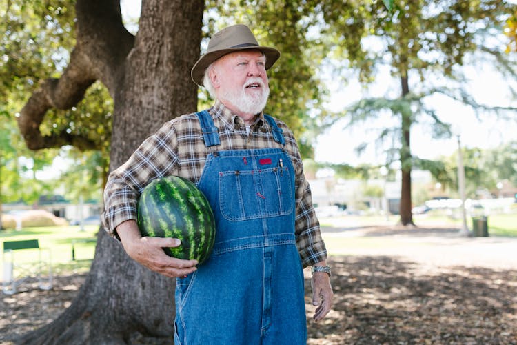 A Man Wearing Hat Holding Watermelon