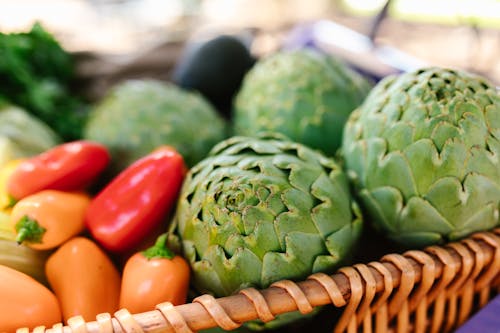 Free Green and Red Vegetables on a Woven Basket Stock Photo