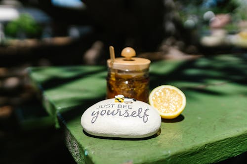 Free A Jar of Honey Beside a Sliced of Lemon on a Wooden Surface Stock Photo