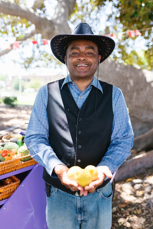 A Man wearing Hat holding Lemon
