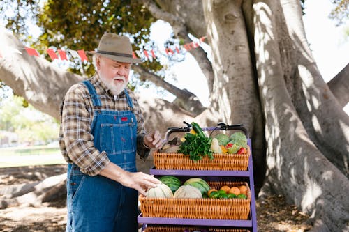 A Farmer Standing by a Fruit Stand