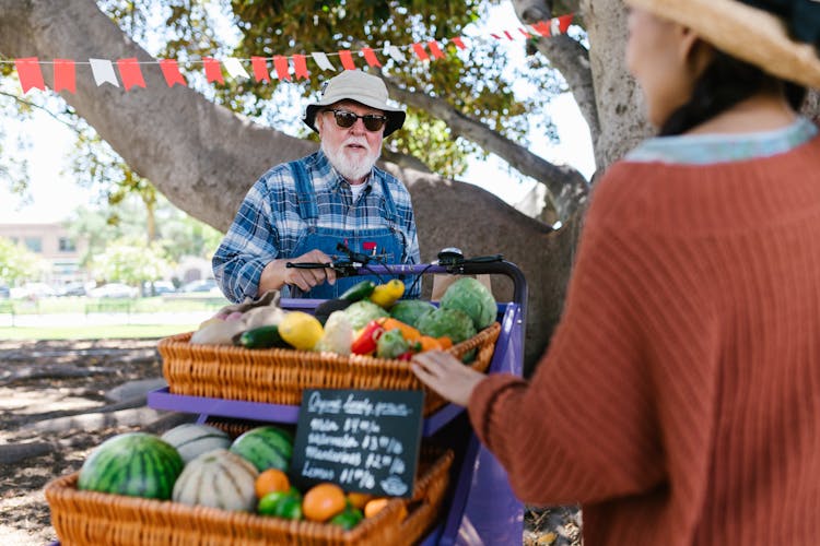 An Elderly Man In Plaid Long Sleeves Talking To His Customer