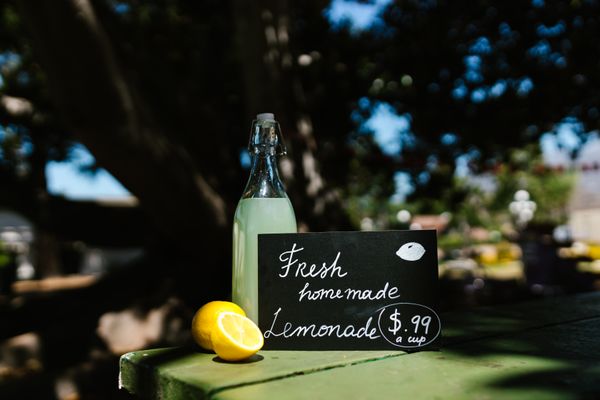 Homemade lemonade in a glass bottle with fresh lemons