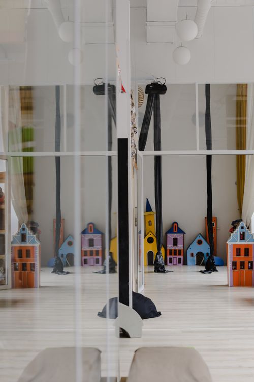 Free Toy houses reflected in a large indoor mirror, creating a playful symmetrical illusion. Stock Photo