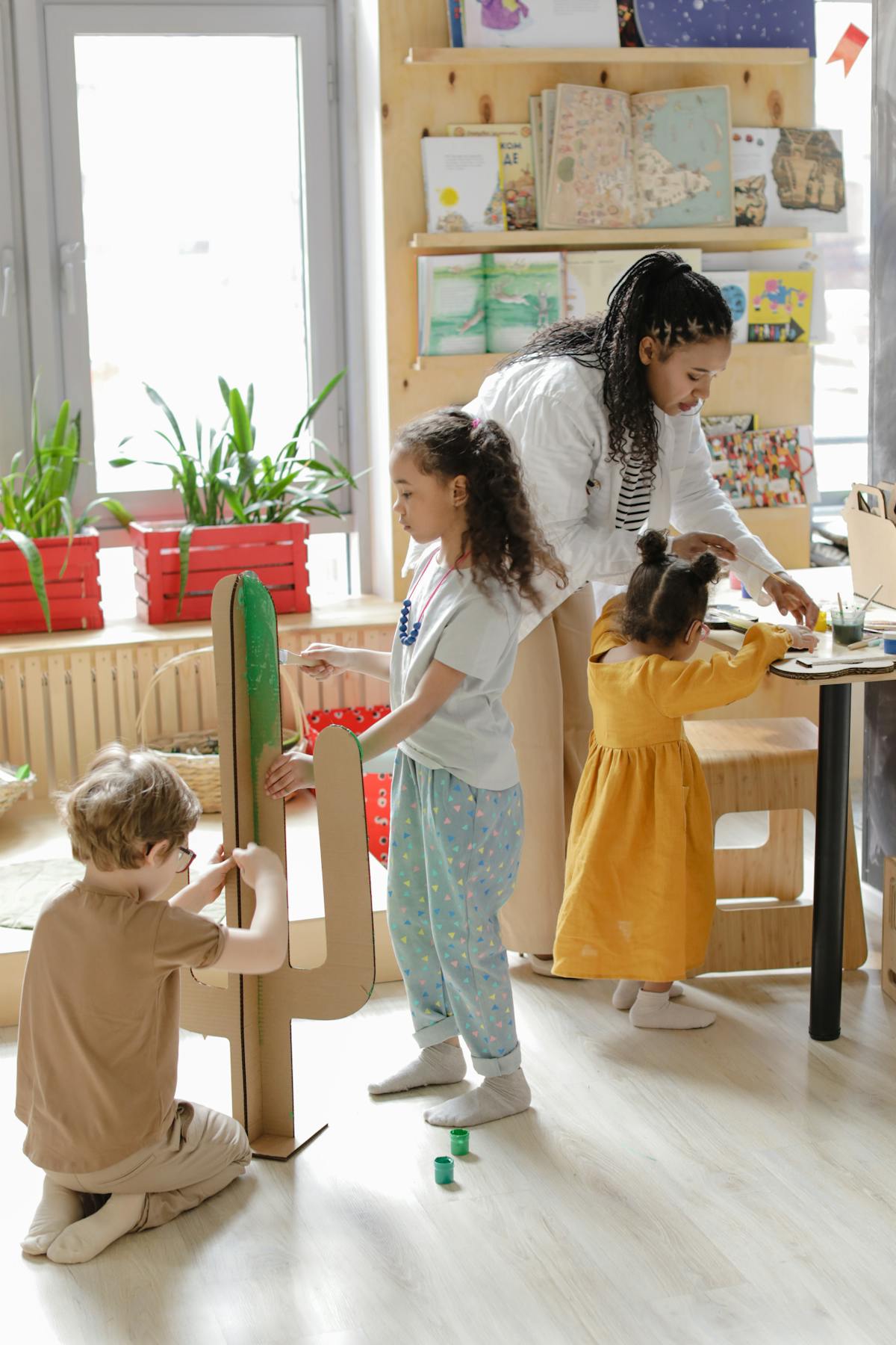 Bambini e insegnante intenti in attività artistiche colorate in classe