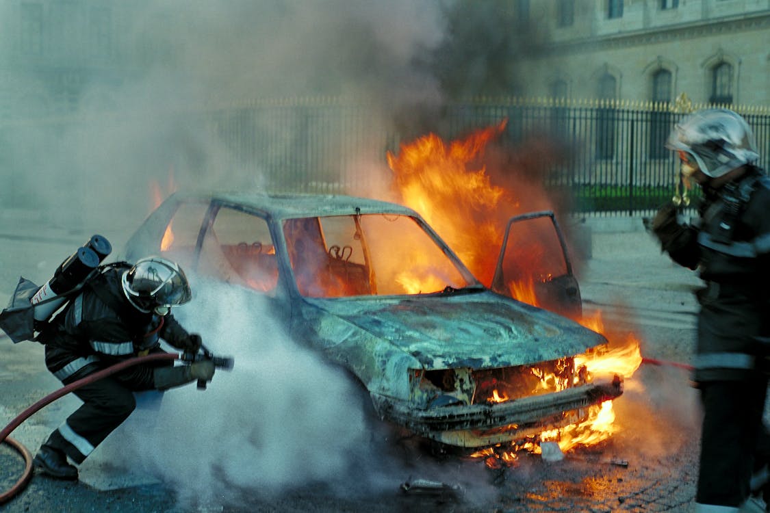 Free Firefighters Extinguishing a Burning Car Stock Photo