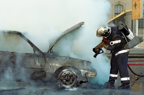 A Firefighter Extinguishing a Broken Car