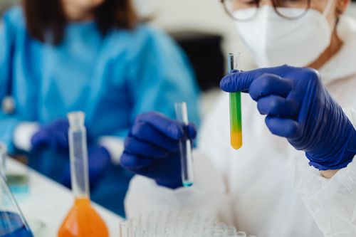 Free Close-up of scientists working with colorful test tubes in a laboratory setting. Stock Photo