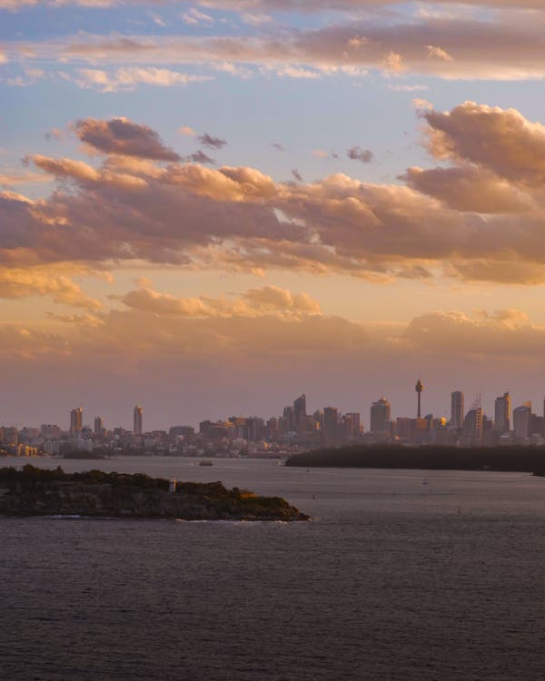 City Skyline Across Body of Water during Sunset