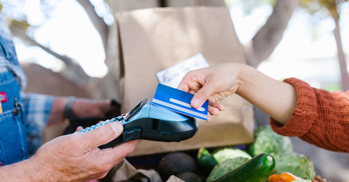 A customer making a contactless payment with a credit card at a farmers market.