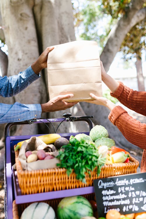 People Holding a Paper Bag