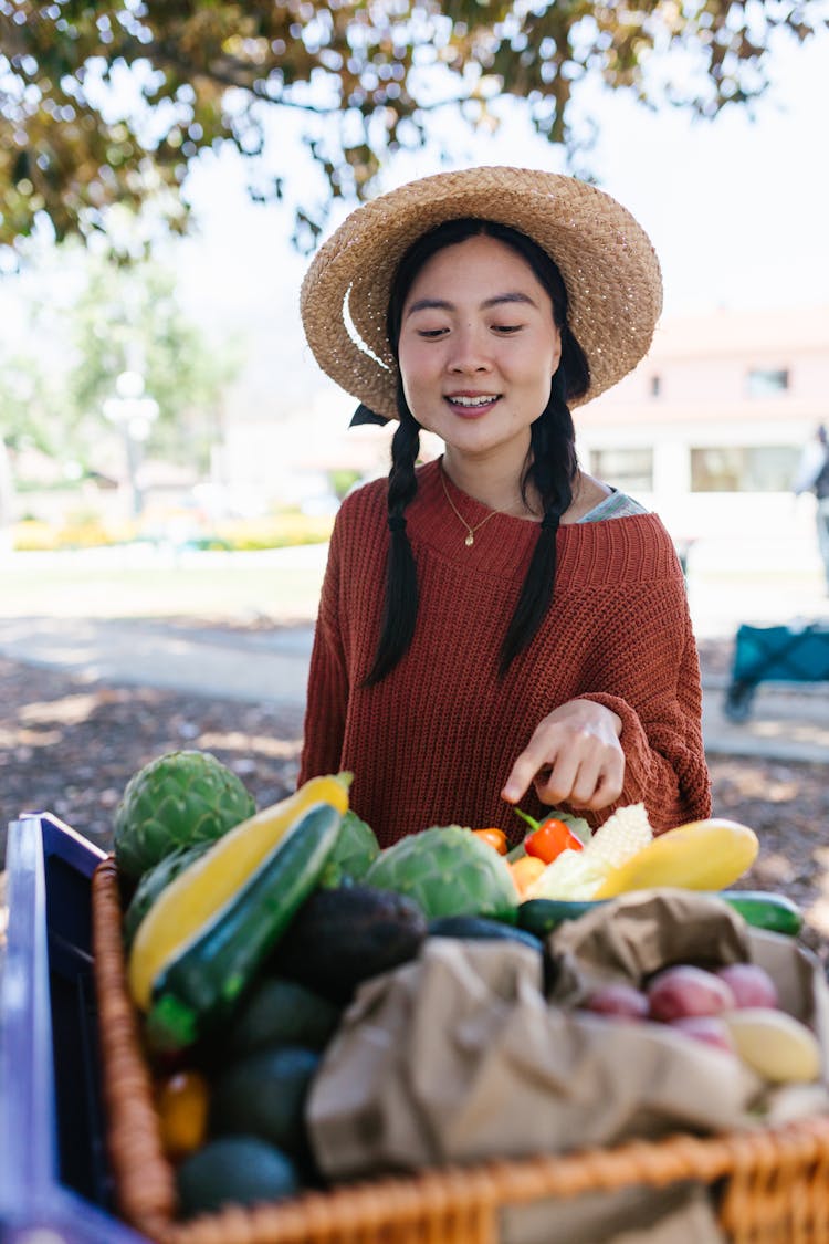 Woman In Brown Knitted Sweater Picking Vegetables