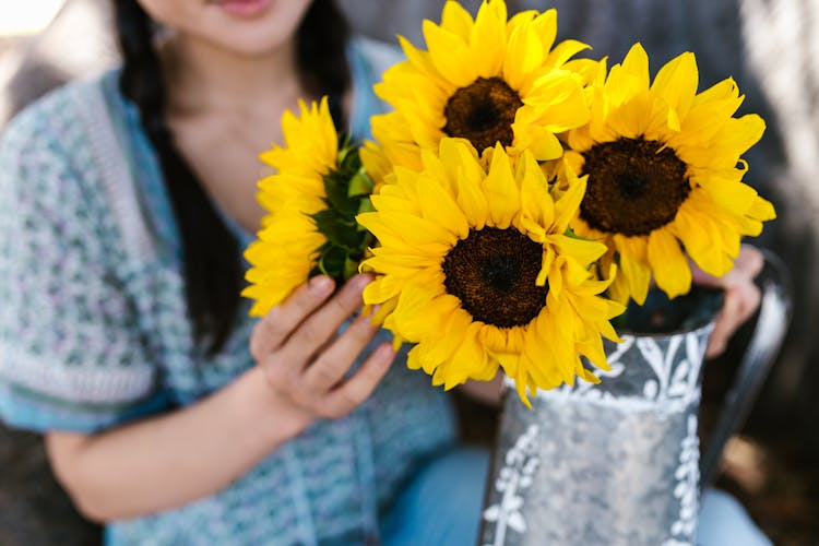 A Person Holding Sunflowers