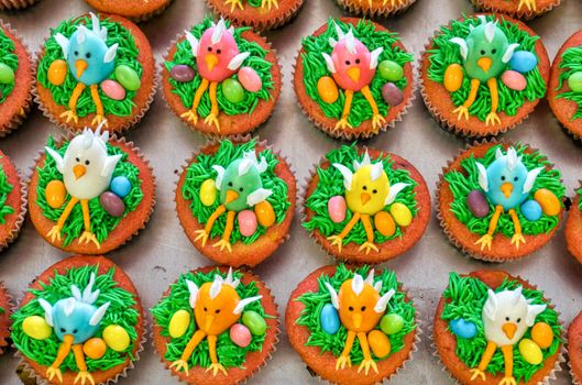 Vibrant cupcakes featuring icing chicks and colorful decorations perfect for Easter celebrations.