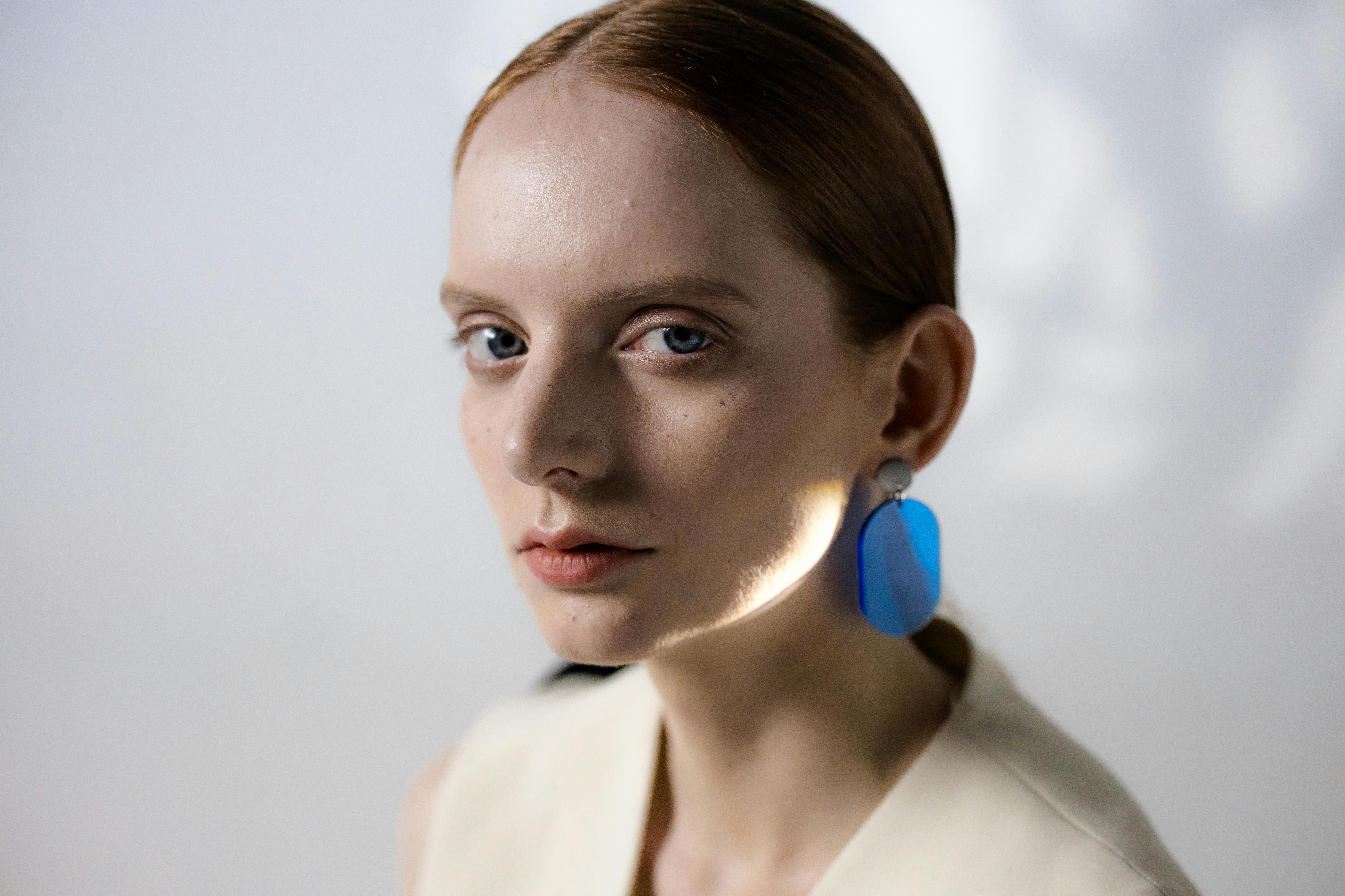 CloseUp Shot of a Pretty Woman Wearing a Blue Earring · Free Stock Photo