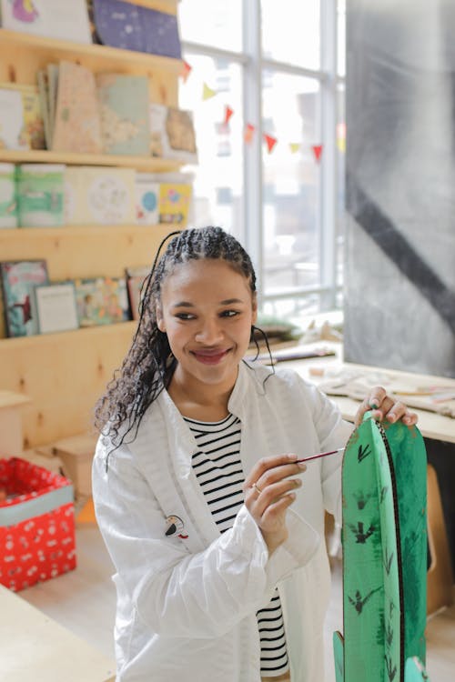 Smiling Young Woman painting a Craft