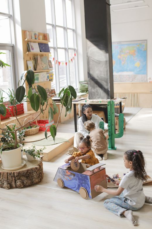 Children doing arts and crafts with their teacher in class