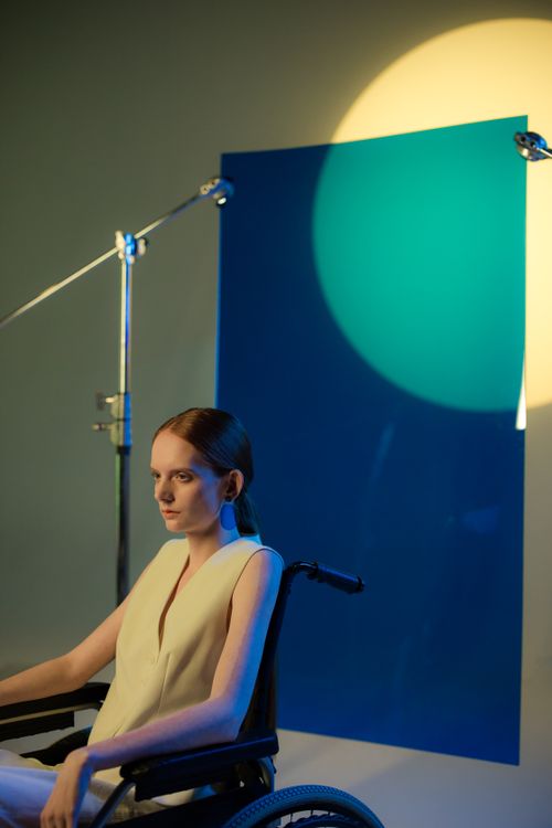 Free A fashionable woman in a wheelchair with creative studio lighting setup. Stock Photo