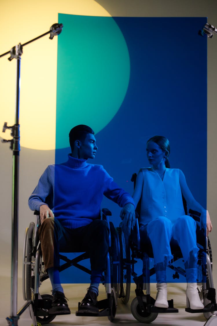 A Couple Holding Hands Behind A Blue Polycarbonate Sheet