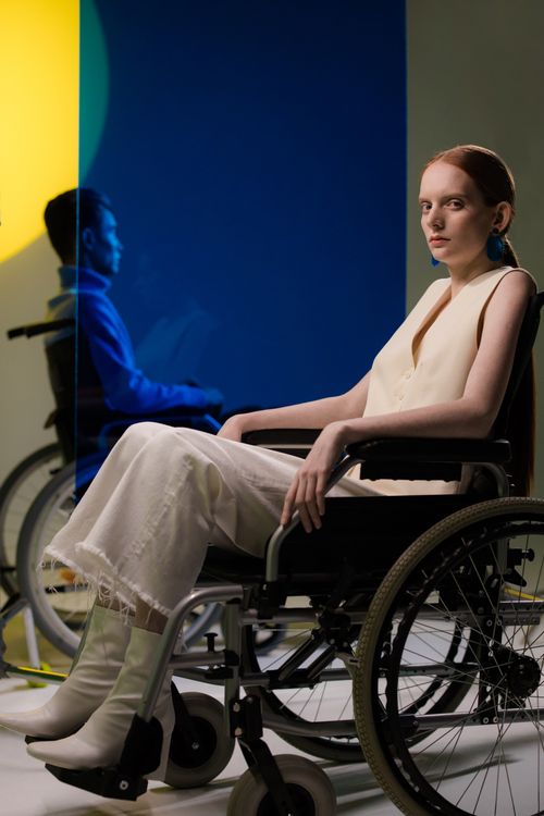 Free Modern portrait of a caucasian woman in a wheelchair against colorful backgrounds, showcasing diversity. Stock Photo