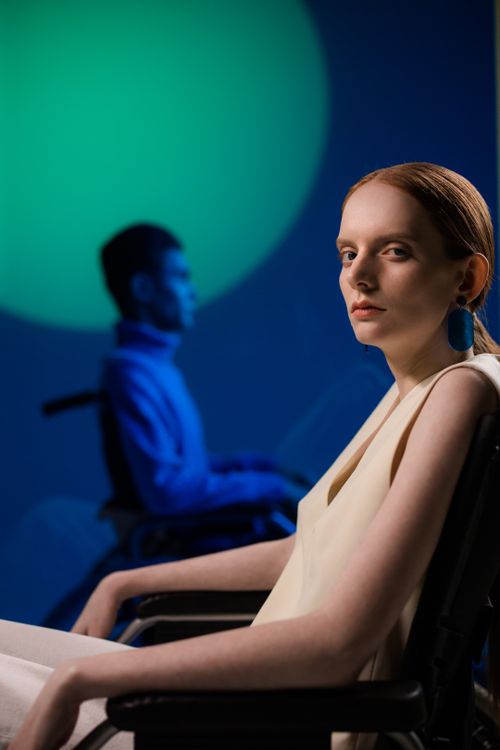 Free Artistic portrait of a woman and man in wheelchairs under creative lighting. Stock Photo