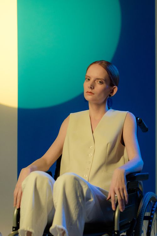 Free Caucasian woman in a wheelchair, studio setup with vibrant lighting showing modern style. Stock Photo