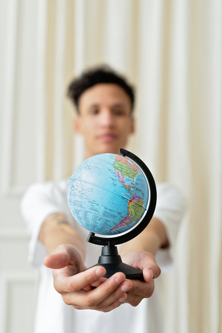 A Man Holding A Globe