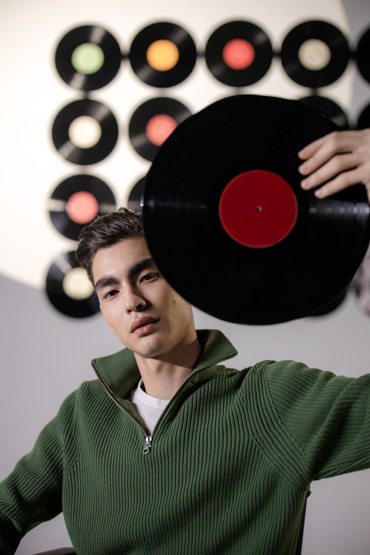 Man In Green Shirt Holding A Vinyl Record