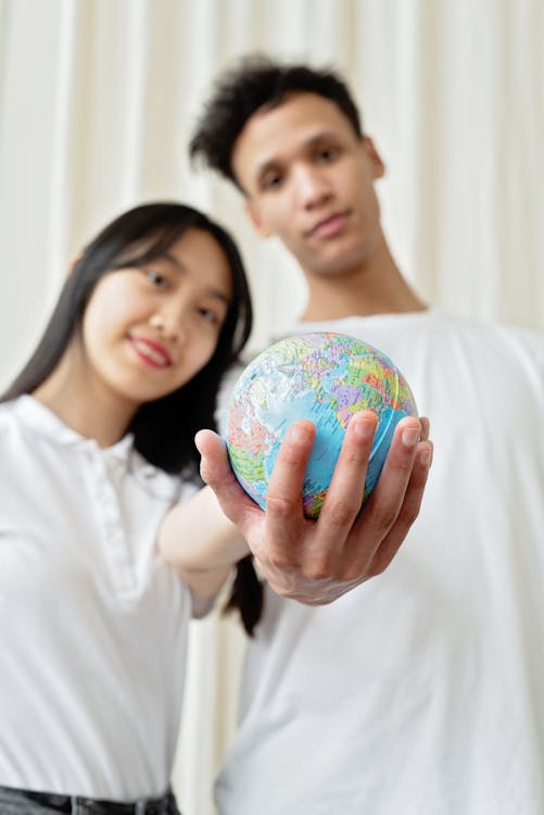 A Man and a Woman Posing with a Globe