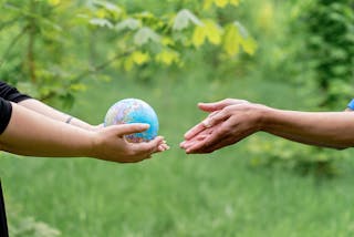Hands Passing the Globe to the Person 