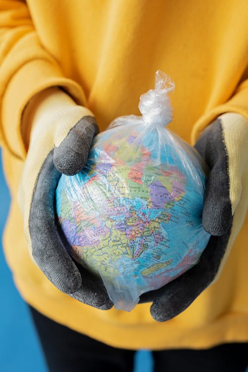 Gratis lagerfoto af Globe, hænder, handsker