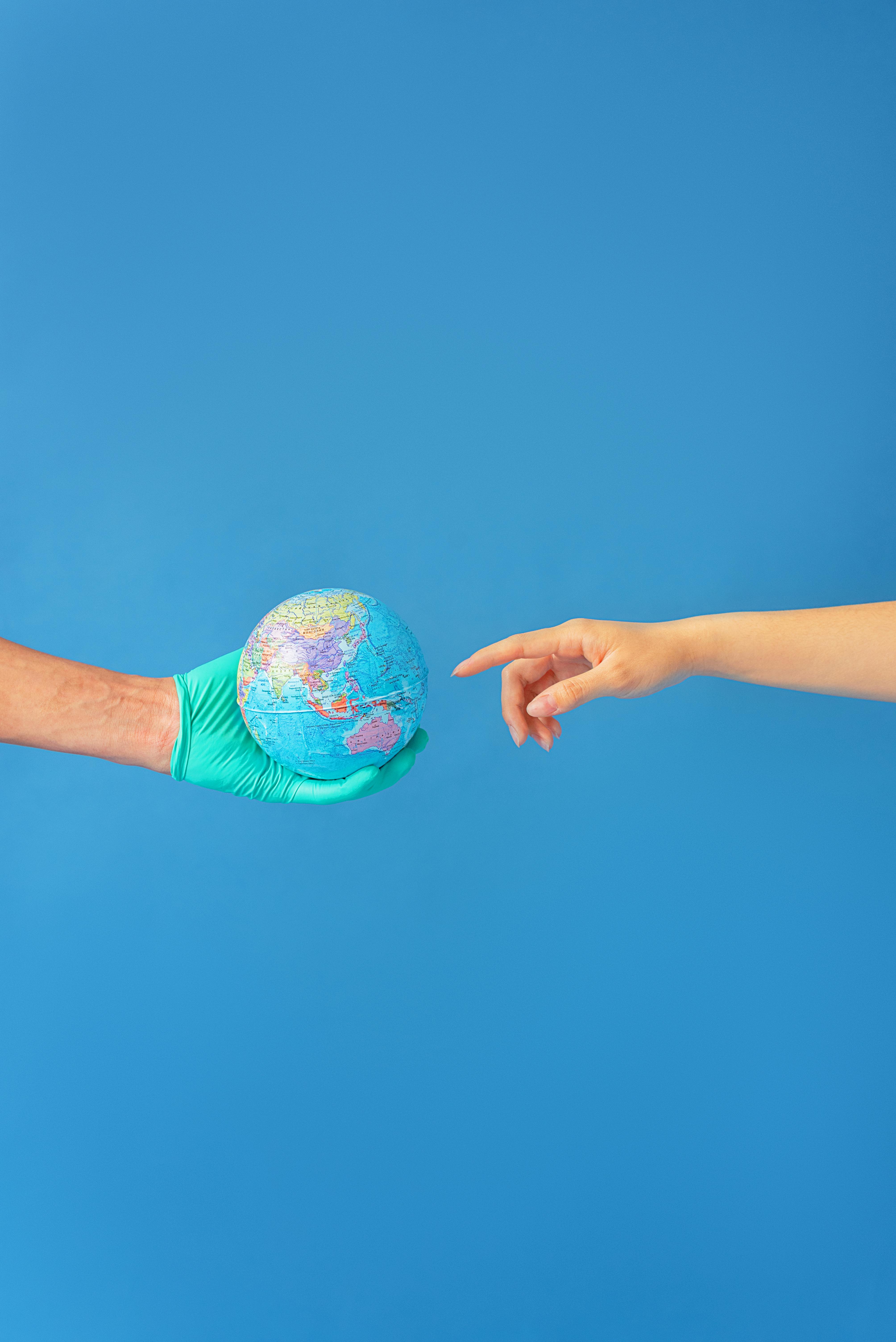 Person wearing Latex Gloves holding a Globe · Free Stock Photo
