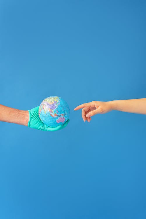 Person wearing Latex Gloves holding a Globe 