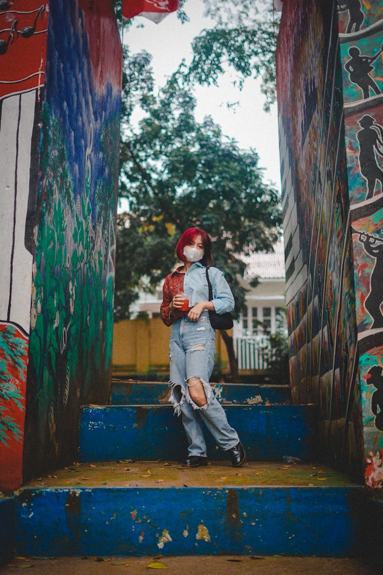 Woman With Dyed Hair Standing Between Painted Walls