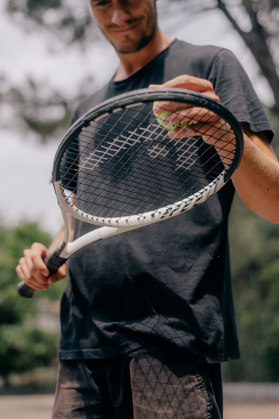 Coach holding a tennis racket outdoors