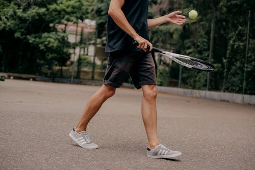 Person holding Tennis Racket and Ball