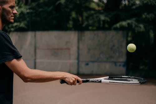 A Man Playing a Tennis Racket and Tennis Ball