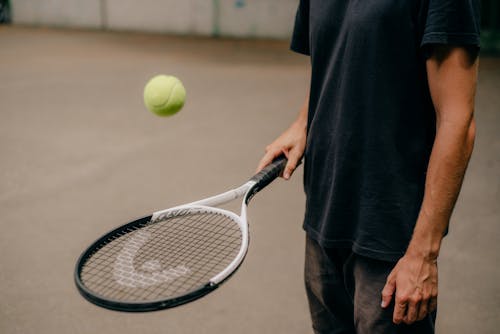 Free Person in Black Shirt Holding Tennis Racket Stock Photo