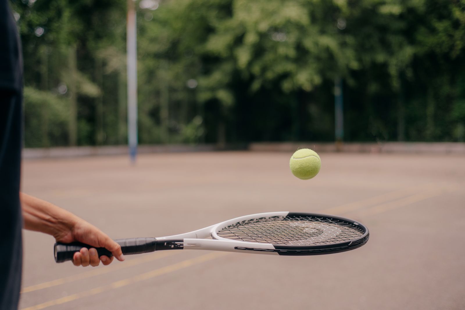 Tennis player gripping a racquet on a bright outdoor court