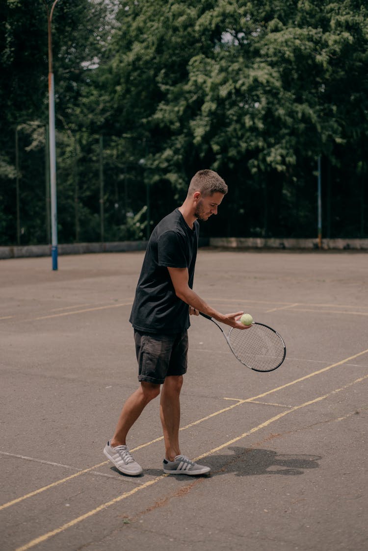 A Man In Black Shirt Playing Tennis