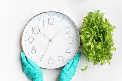 Hands holding a white wall clock — Mikhail Nilov on Pexels